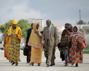Eine Gruppe von Menschen begleitet die Sonderbeauftrage über den Flughafen Aden Adde in Mogadischu, Somalia 